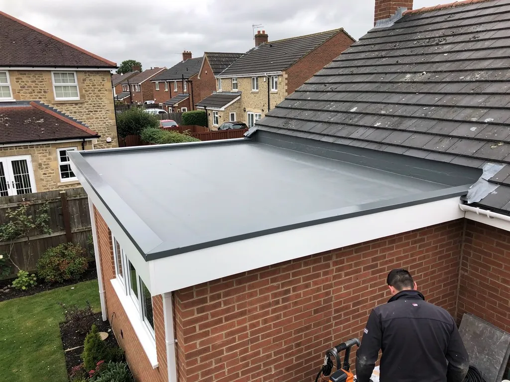 Finished grey GRP flat roof on a single-storey brick extension