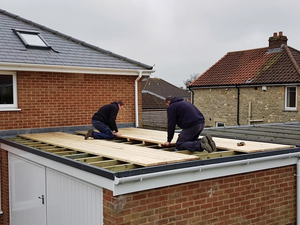 Roofers laying new boards on a flat garage roof