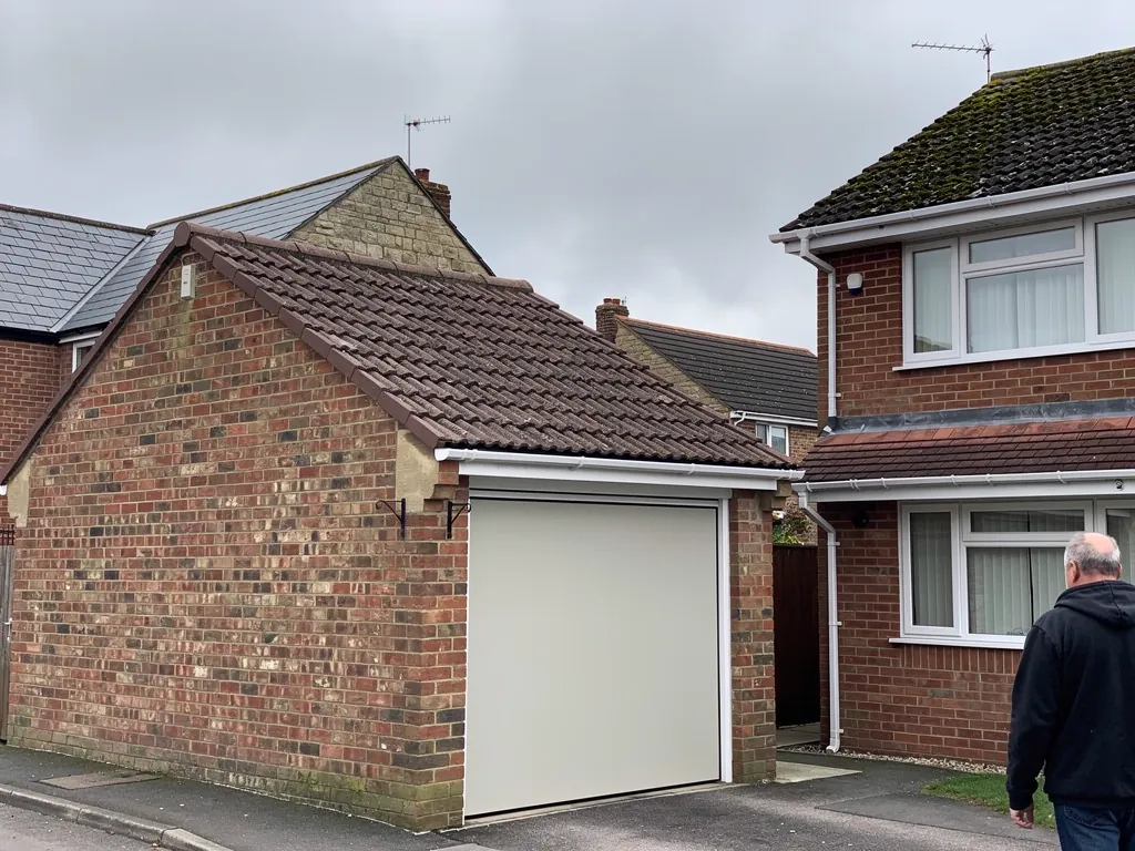 Brick garage with a new brown concrete tile pitched roof
