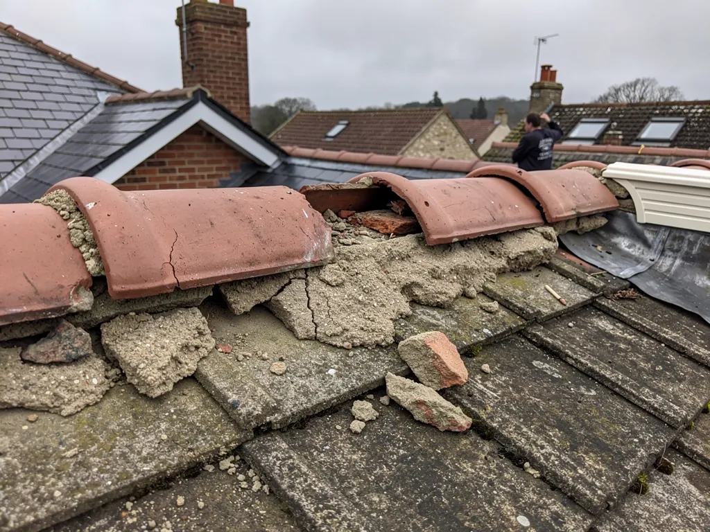 Crumbling mortar beneath old half-round clay ridge tiles