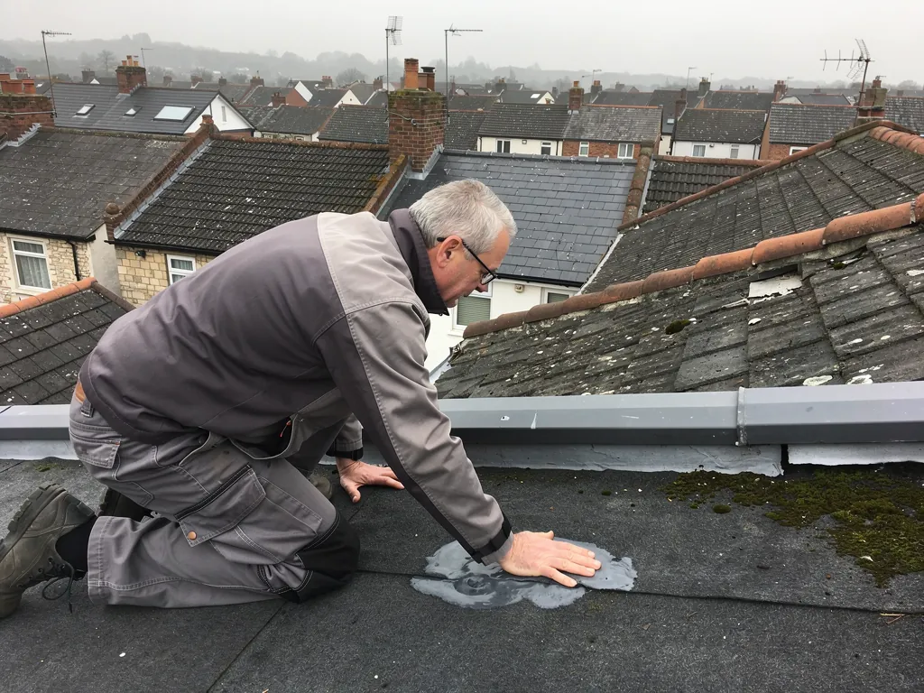 Surveyor pressing a blister on a felt flat roof