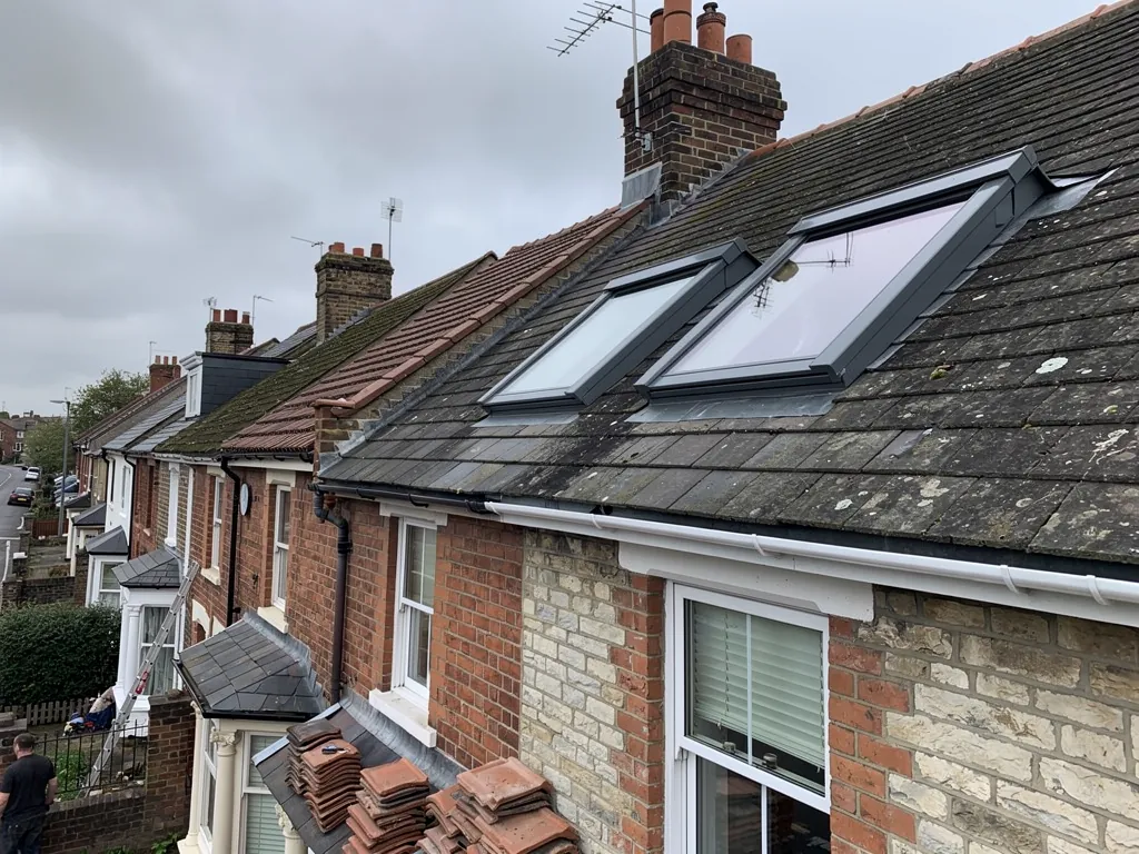 Two grey-framed roof windows in a slate terrace roof