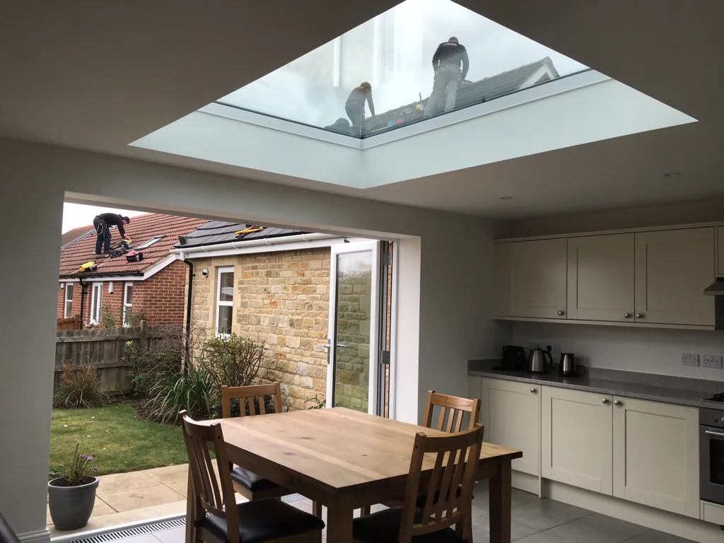 Kitchen-diner lit by a large flat rooflight in the ceiling