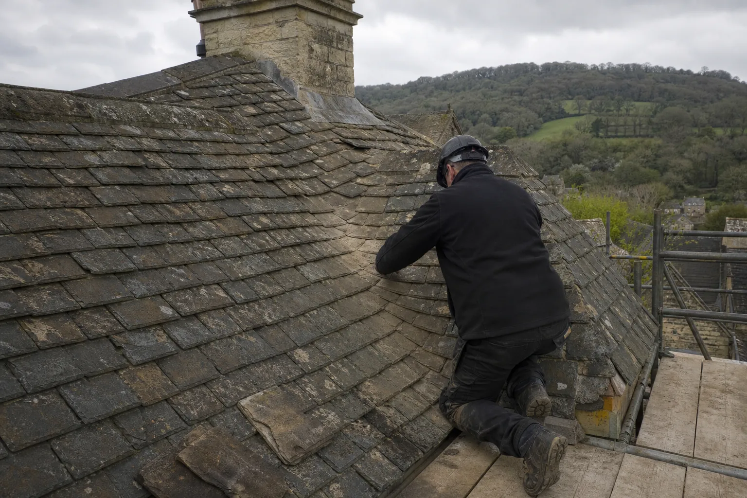 Roofer working on a sweeping stone slate roof valley
