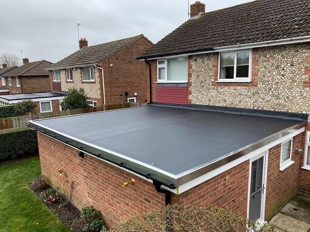 Finished black rubber flat roof on a brick single-storey extension