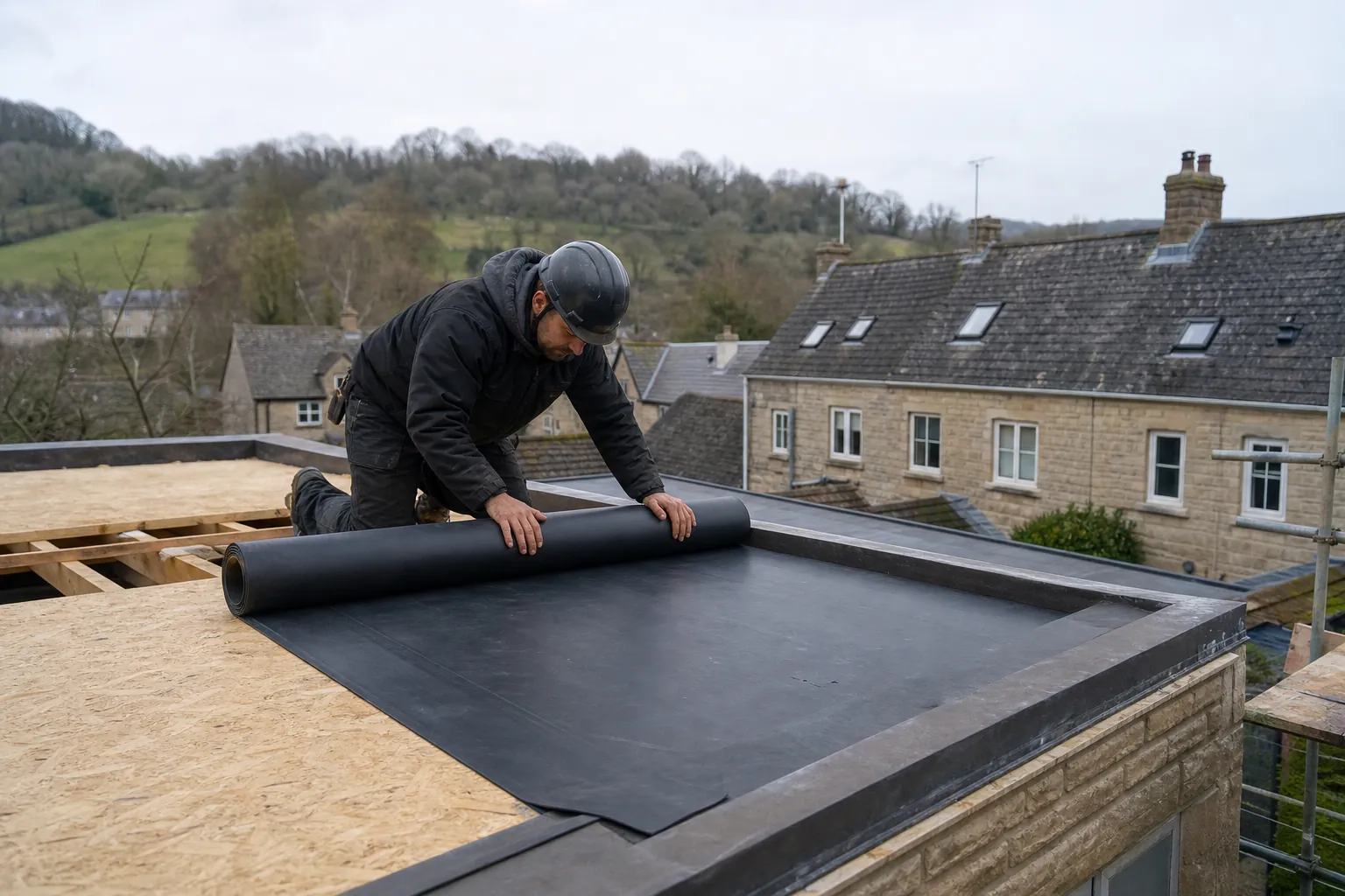 Roofer unrolling EPDM rubber membrane over a new roof deck